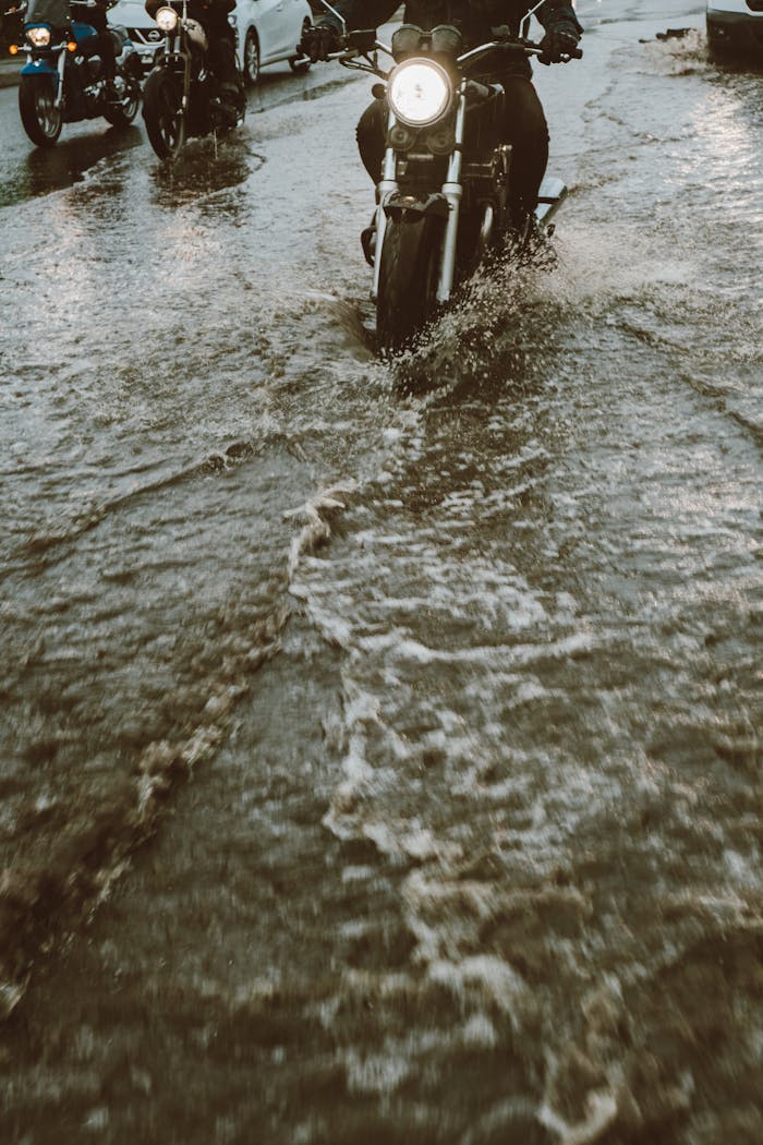 A Person Riding a Motorbike on Flooded Road